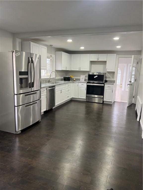 kitchen featuring dark wood-style flooring, a sink, stainless steel appliances, recessed lighting, and white cabinetry