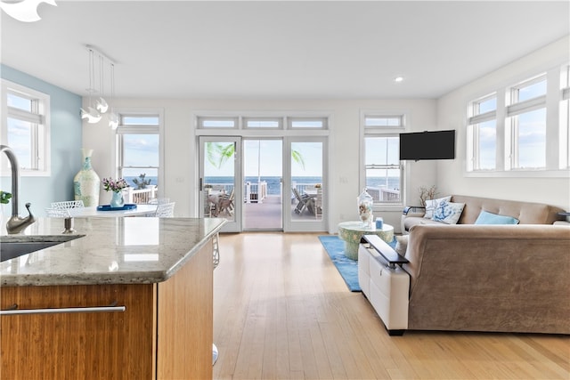 399 Atlantic Ave, Westerly, RI 02891 - kitchen featuring light wood-style flooring, light stone countertops, open floor plan, brown cabinetry, and recessed lighting