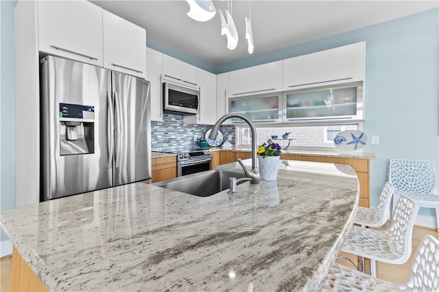 399 Atlantic Ave, Westerly, RI 02891 - kitchen featuring stainless steel appliances, backsplash, modern cabinets, light stone counters, and a kitchen breakfast bar