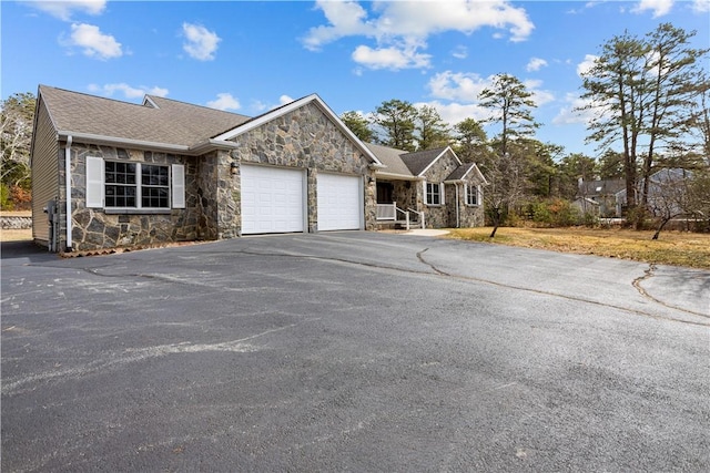 single story home with a garage, stone siding, driveway, and a shingled roof