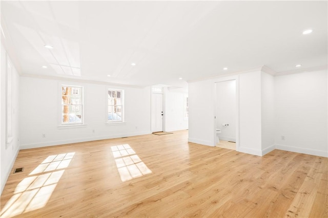 interior space with visible vents, light wood finished floors, baseboards, recessed lighting, and ornamental molding