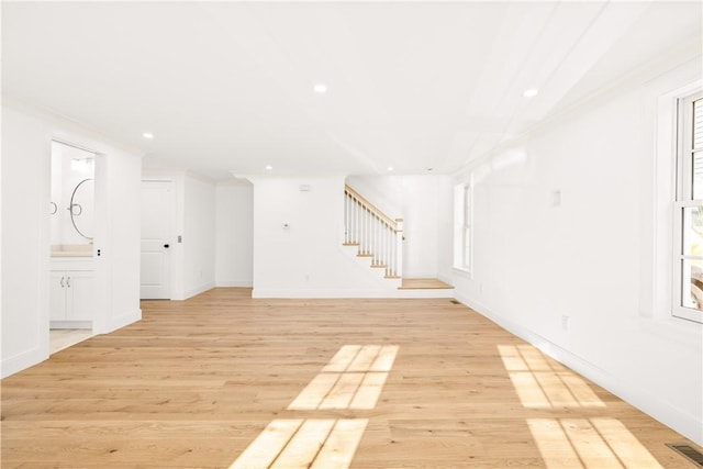 interior space featuring visible vents, light wood-style floors, ornamental molding, and stairs