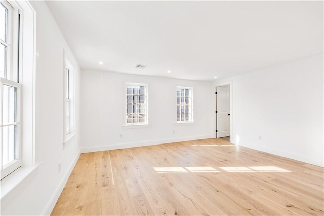 empty room featuring light wood finished floors, visible vents, recessed lighting, and baseboards