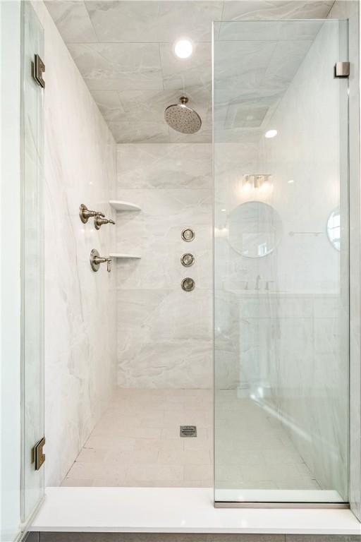 bathroom featuring a marble finish shower
