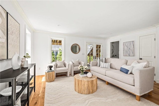 living area featuring light wood finished floors, french doors, baseboards, and ornamental molding
