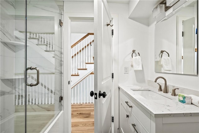 bathroom with a shower stall, vanity, and wood finished floors