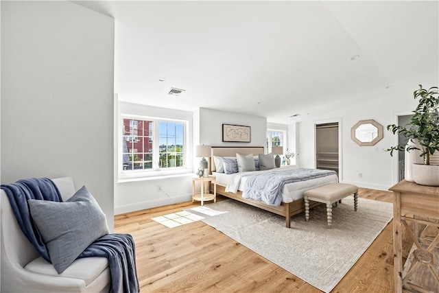 bedroom featuring visible vents, baseboards, and light wood-style flooring
