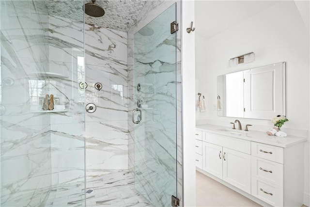full bath with a marble finish shower and vanity