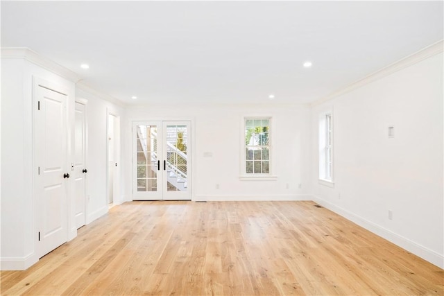 empty room featuring light wood finished floors, baseboards, ornamental molding, recessed lighting, and french doors