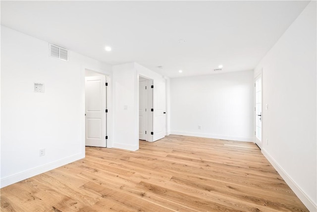 unfurnished room with recessed lighting, light wood-style floors, visible vents, and baseboards