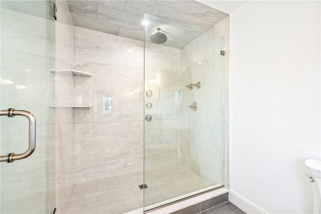 full bathroom featuring a shower stall and toilet