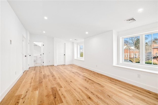 unfurnished room with light wood finished floors, visible vents, recessed lighting, and baseboards