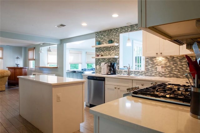 kitchen with tasteful backsplash, visible vents, light countertops, stainless steel dishwasher, and a sink
