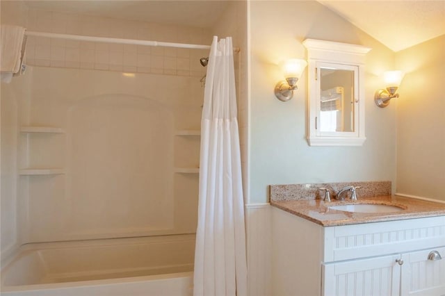 full bathroom featuring vanity, lofted ceiling, and shower / bath combo