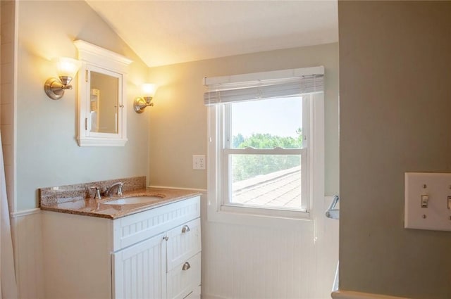 bathroom with vanity and lofted ceiling