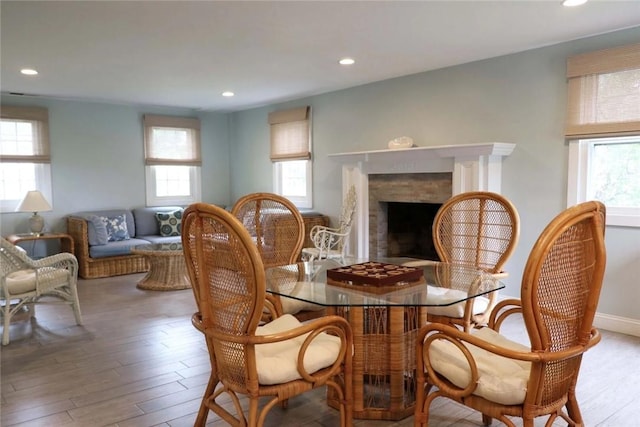 dining area featuring recessed lighting, baseboards, wood finished floors, and a fireplace