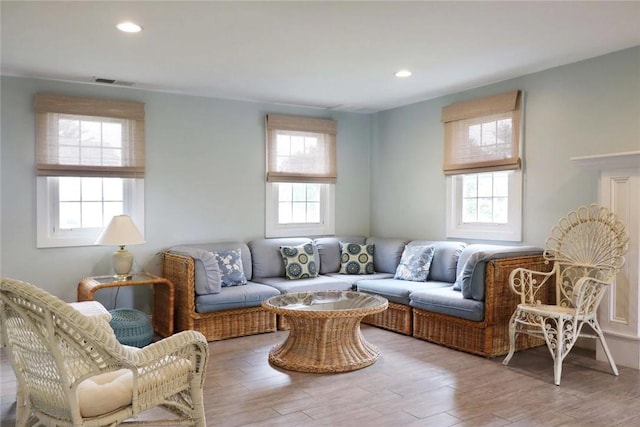 living area with recessed lighting, wood finished floors, and visible vents