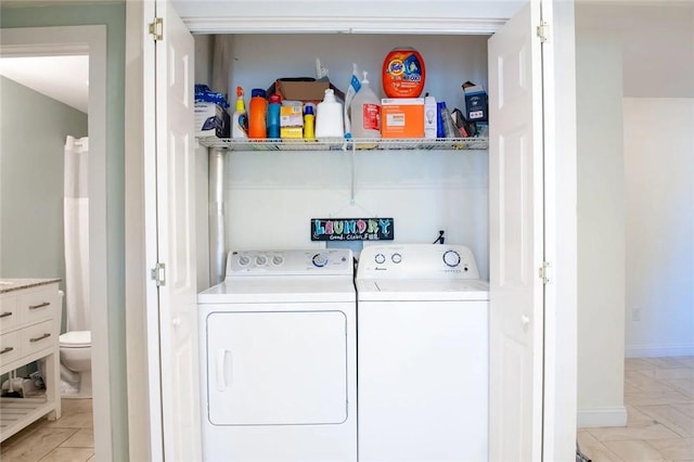 washroom with baseboards, laundry area, and washer and clothes dryer