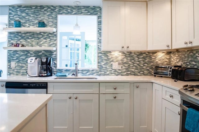 kitchen with open shelves, stainless steel appliances, light countertops, and a sink