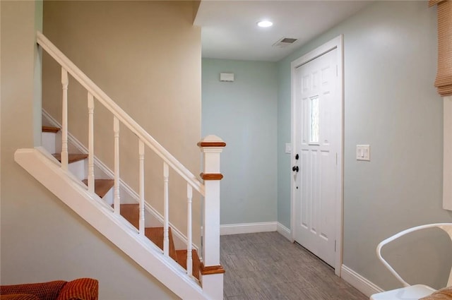 entryway featuring visible vents, baseboards, stairs, recessed lighting, and wood finished floors