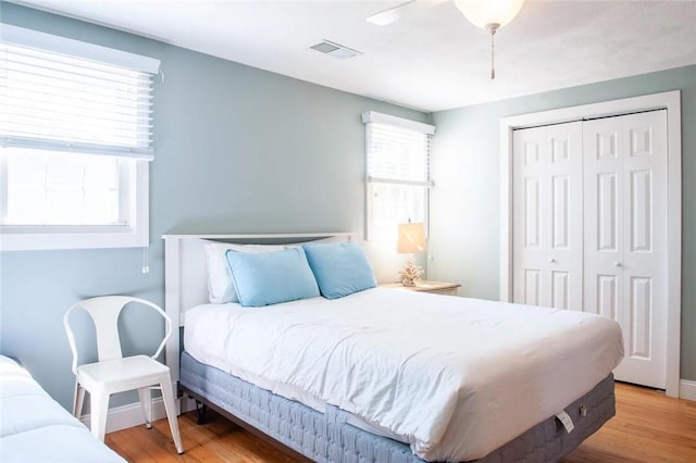 bedroom featuring a closet, visible vents, a ceiling fan, and wood finished floors