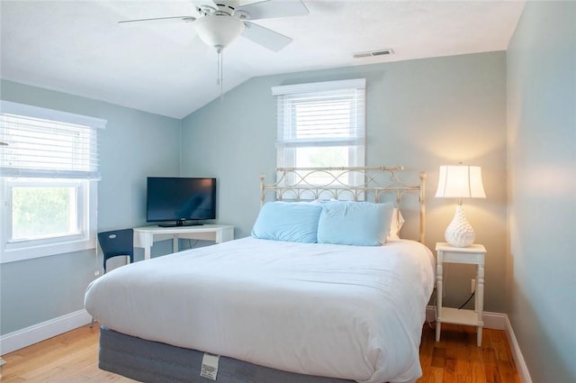 bedroom featuring multiple windows, wood finished floors, visible vents, and baseboards