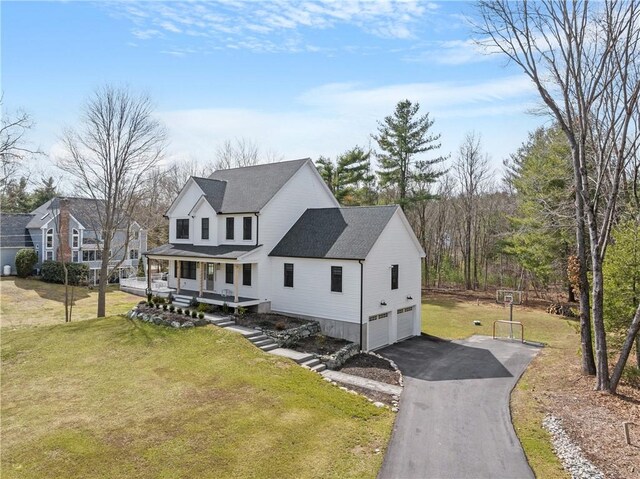 modern farmhouse style home featuring a front lawn, aphalt driveway, roof with shingles, covered porch, and an attached garage