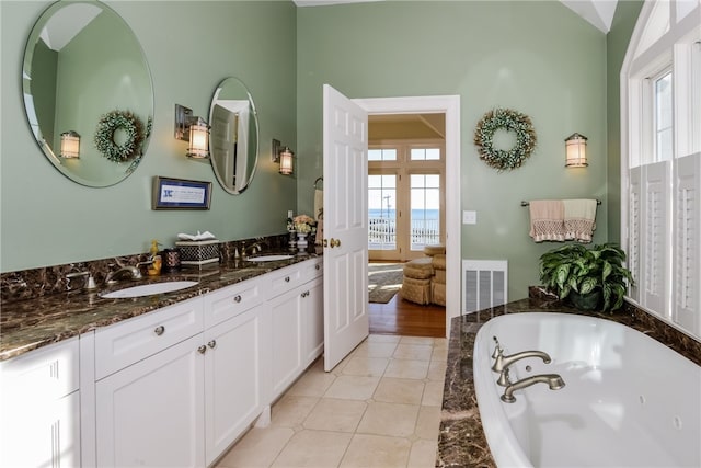 full bathroom with tile patterned flooring, double vanity, visible vents, and a sink