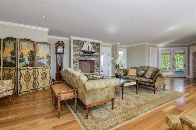 living area with recessed lighting, a fireplace, ornamental molding, and wood finished floors