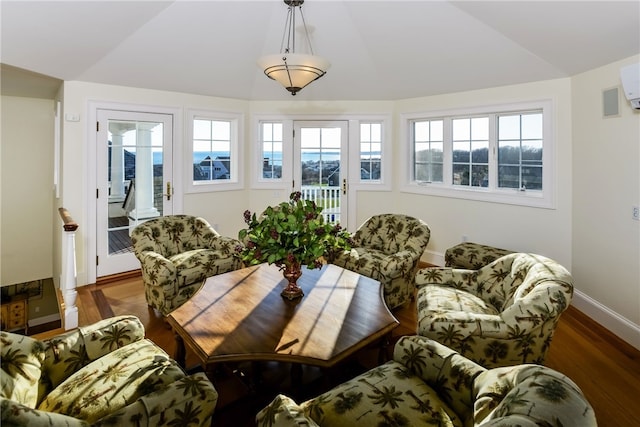 interior space featuring baseboards, vaulted ceiling, and wood finished floors