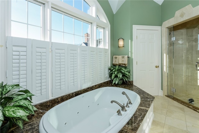 bathroom featuring a whirlpool tub, tile patterned flooring, vaulted ceiling, and a stall shower