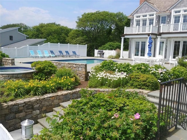 view of pool featuring an outdoor hot tub, a patio area, fence, french doors, and a fenced in pool