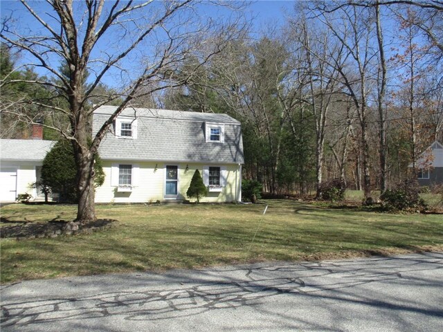 view of front of home featuring a gambrel roof, a front yard, and roof with shingles