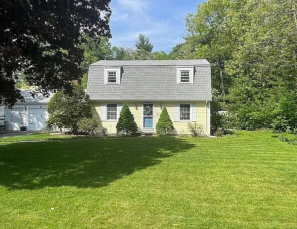 view of front of house featuring a gambrel roof and a front yard