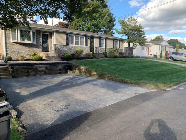 single story home featuring stone siding and a front yard