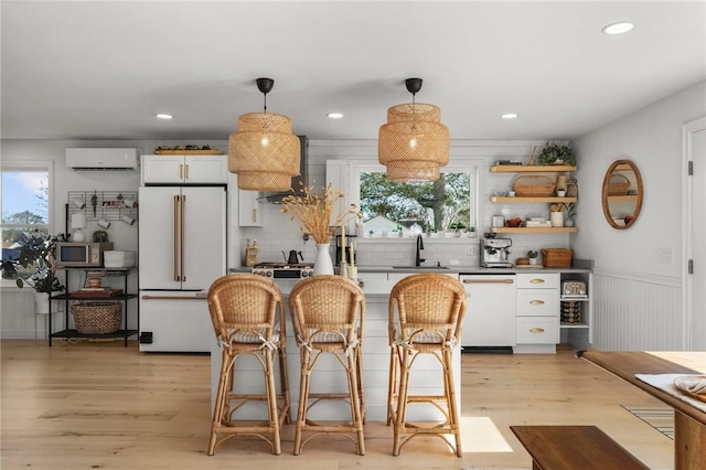 kitchen with a wall unit AC, white cabinets, a sink, white appliances, and backsplash