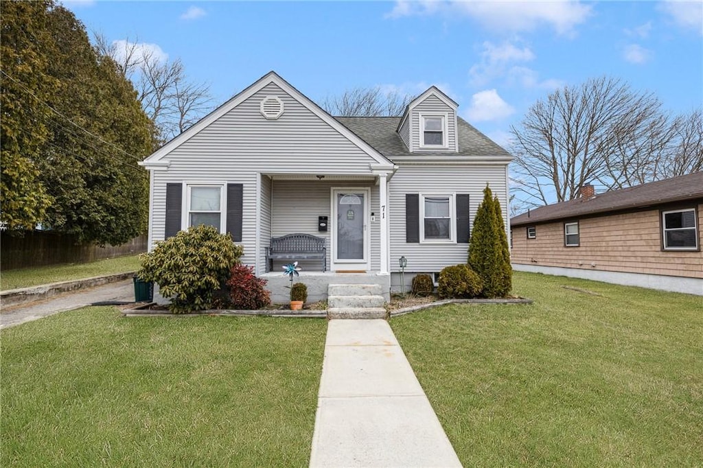 view of front of home with roof with shingles and a front lawn