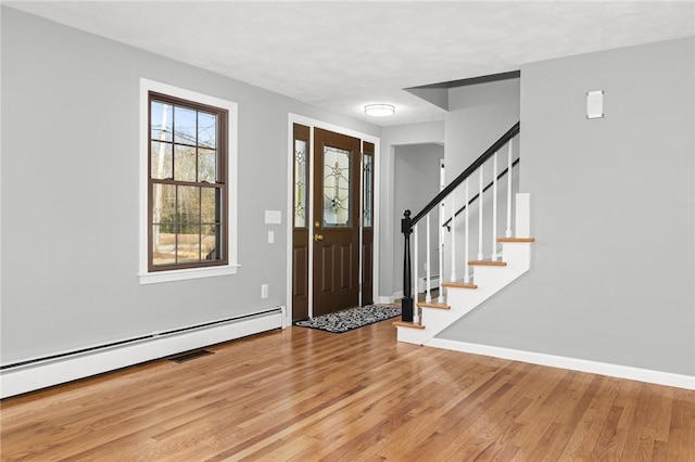 10 Eastgate Dr, Coventry, RI 02816 - entrance foyer with baseboards, wood finished floors, stairs, and a baseboard radiator