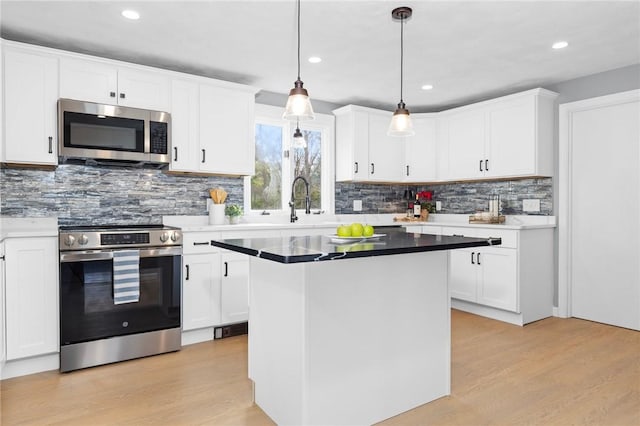 10 Eastgate Dr, Coventry, RI 02816 - kitchen featuring backsplash, light wood finished floors, appliances with stainless steel finishes, and white cabinetry