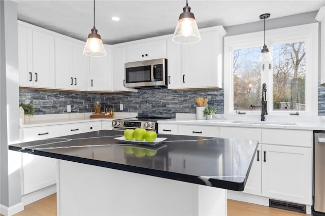 10 Eastgate Dr, Coventry, RI 02816 - kitchen featuring backsplash, appliances with stainless steel finishes, white cabinetry, and a sink
