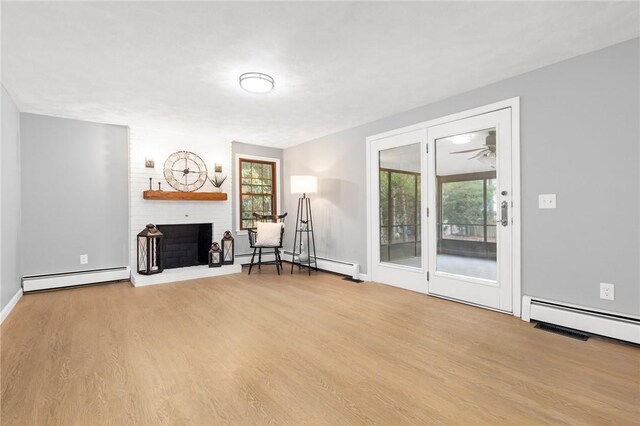 10 Eastgate Dr, Coventry, RI 02816 - unfurnished room with wood finished floors, a baseboard heating unit, and a brick fireplace