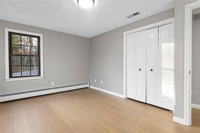 10 Eastgate Dr, Coventry, RI 02816 - unfurnished bedroom featuring a baseboard radiator, baseboards, wood finished floors, and visible vents