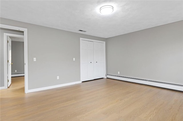 10 Eastgate Dr, Coventry, RI 02816 - unfurnished bedroom with a baseboard heating unit, visible vents, wood finished floors, and baseboards