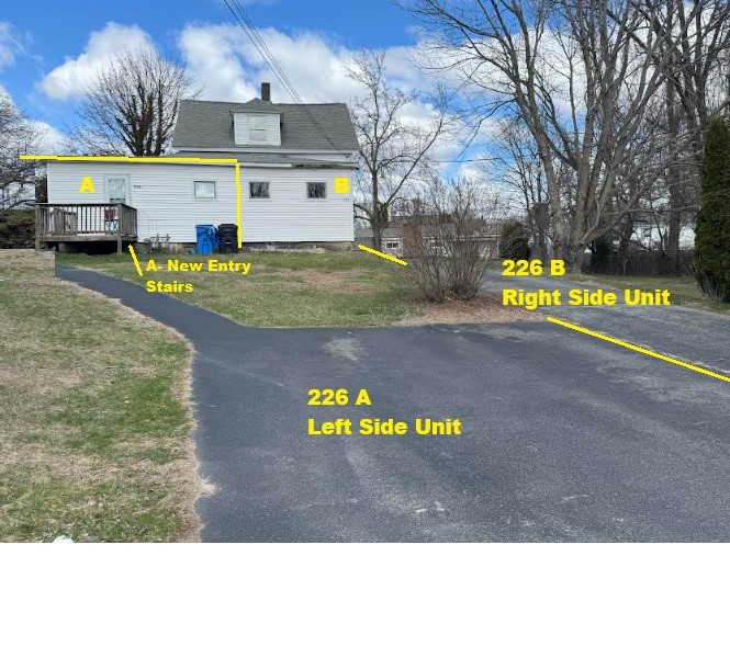 exterior space featuring a deck, uncovered parking, a chimney, and a lawn