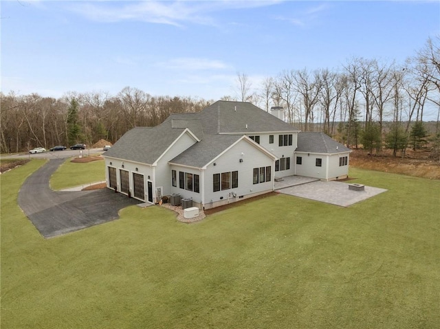 105 Princess Pine Dr, East Greenwich, RI 02818 - rear view of house with a lawn, aphalt driveway, roof with shingles, an attached garage, and a patio area