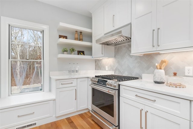 105 Princess Pine Dr, East Greenwich, RI 02818 - kitchen with gas stove, open shelves, decorative backsplash, under cabinet range hood, and light wood-type flooring