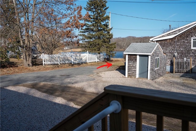 view of yard with fence, a shed, and an outbuilding