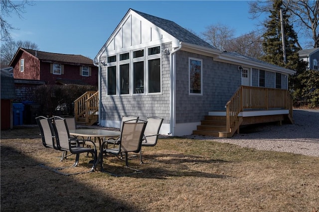 rear view of property with a yard, a shingled roof, and board and batten siding