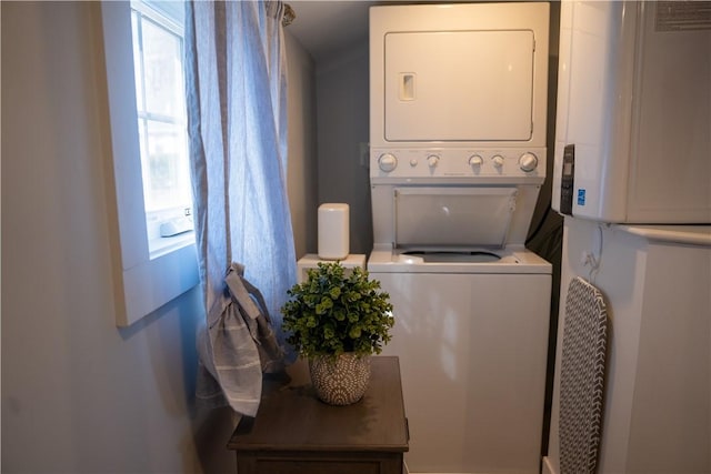clothes washing area featuring stacked washing maching and dryer