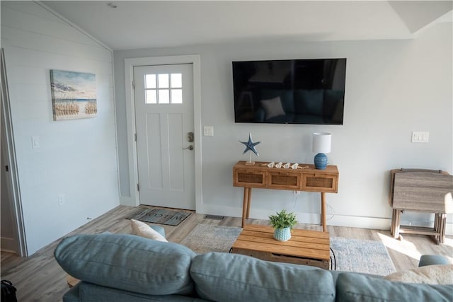 living area with wood finished floors and vaulted ceiling